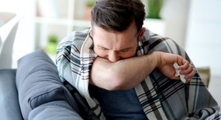 man-coughing-in-his-elbow-X46CDUW.jpg